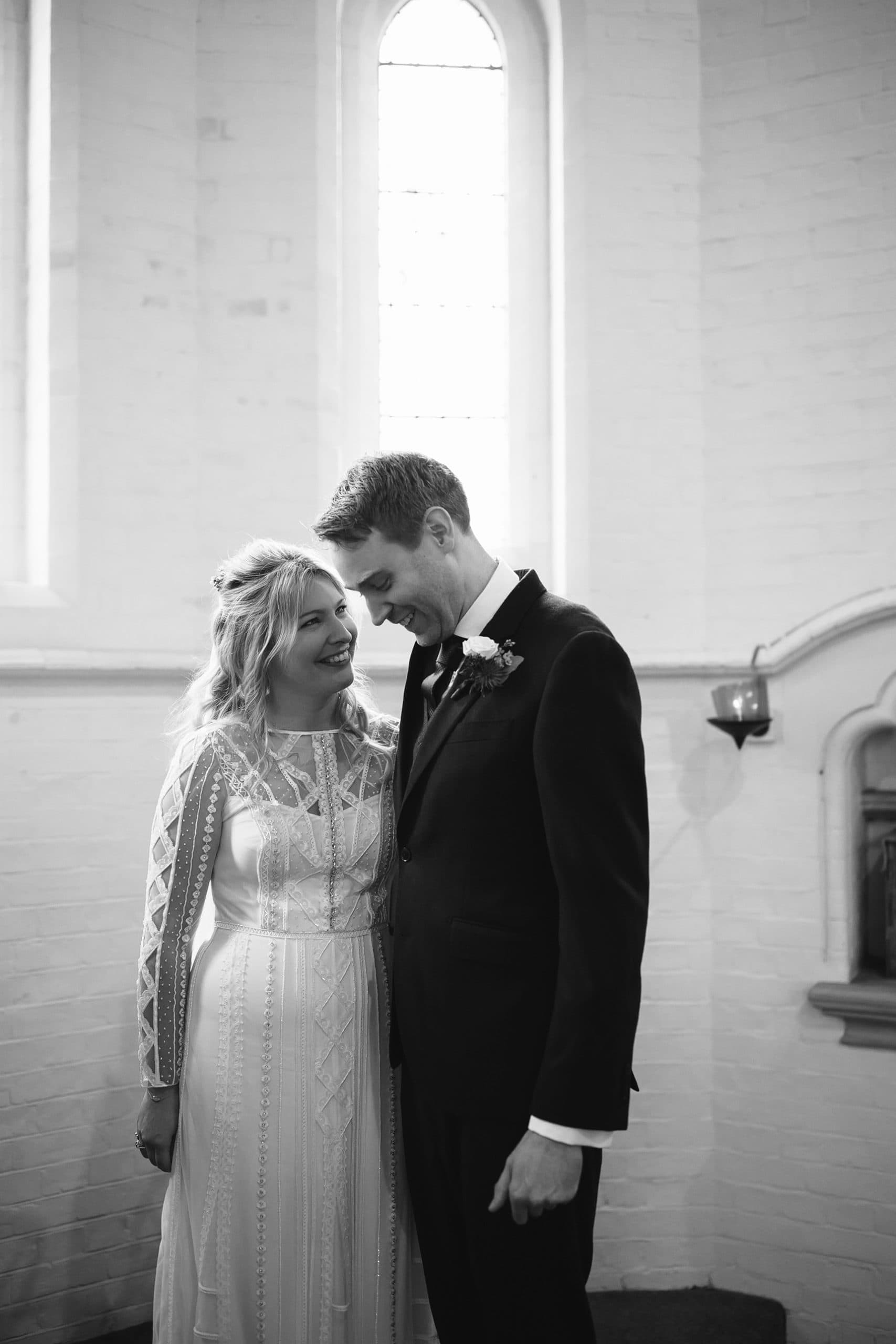 Black and white photo of a bride and groom having a private moment