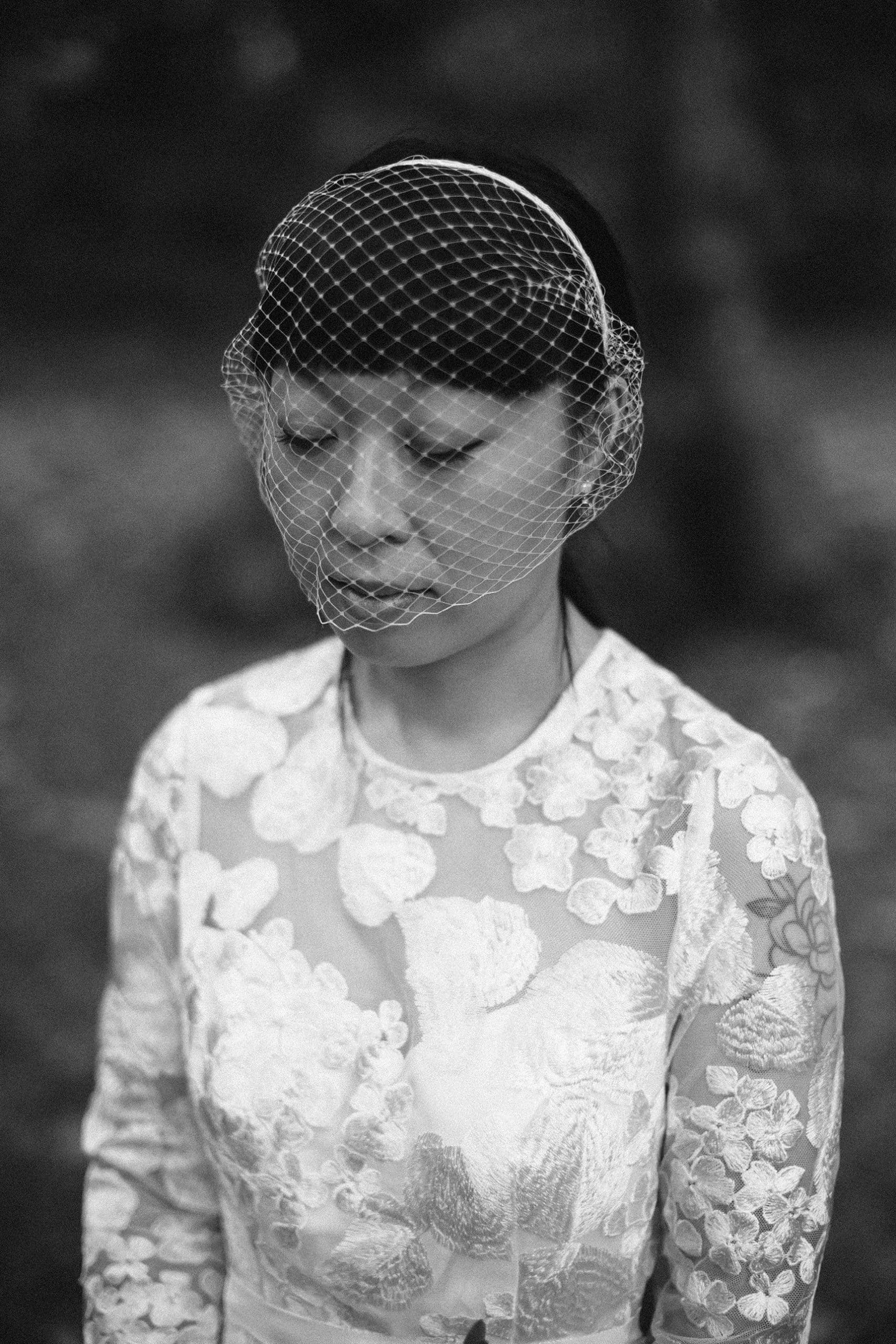Black-and-white photograph of a bride with her eyes closed