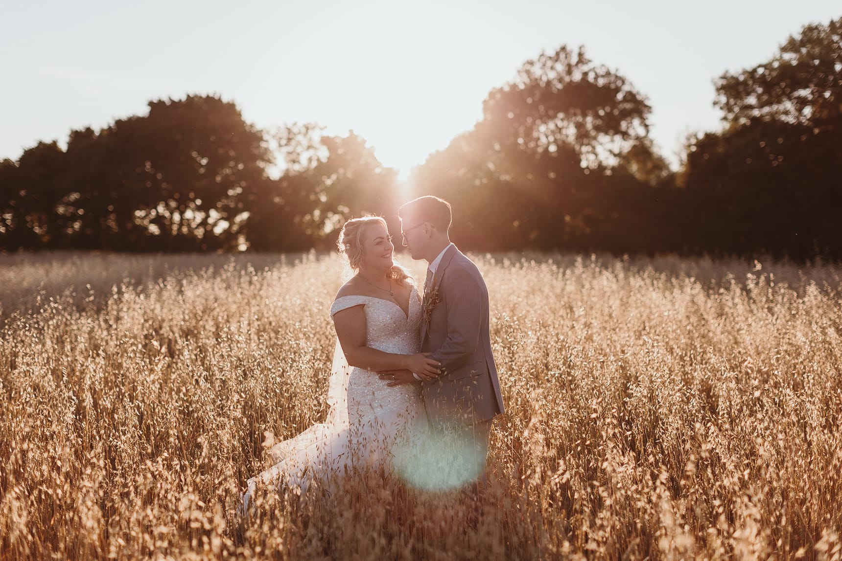 Sunset photo of a bride and groom in the cornfield with warm light
