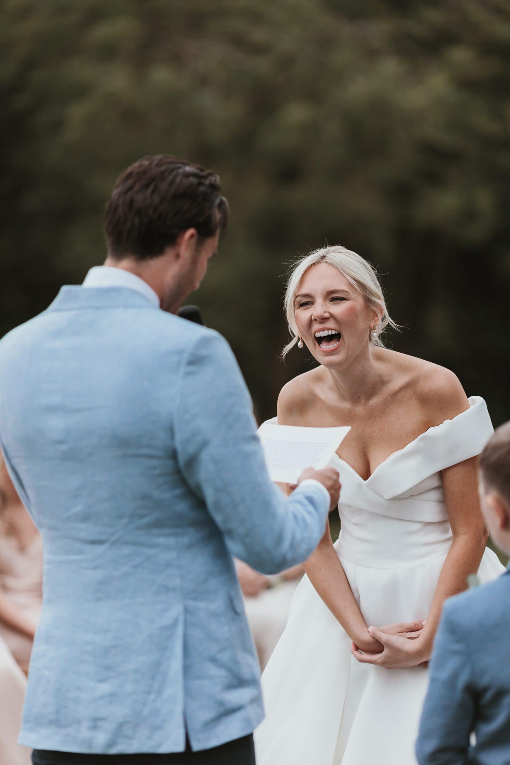 Bride with a massive smile on her face during her husbands ceremony speech