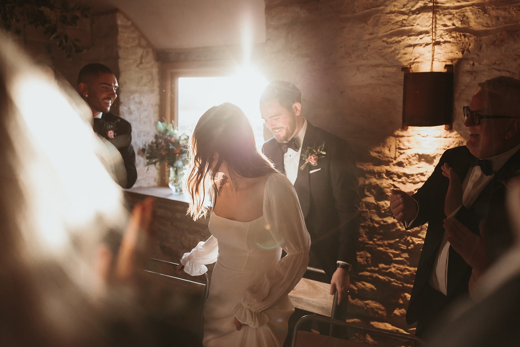 Groom pulling out a chair so his bride can sit down with dramatic lighting